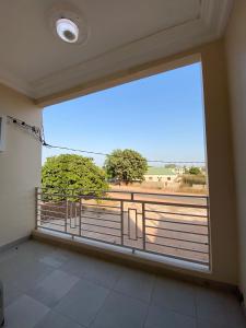 Cette chambre dispose d'une grande fenêtre et d'un balcon. dans l'établissement KMR Apartment - Kumba, à Serekunda
