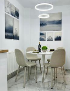 a dining room with a white table and chairs at MarbleHome~Straja/Lupeni in Lupeni +28 photos