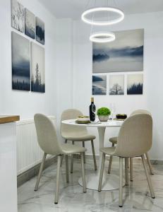 a dining room with a white table and chairs at MarbleHome~Straja/Lupeni in Lupeni