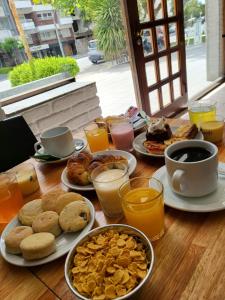 un tavolo ricoperto di piatti di prodotti per la colazione e bevande di Hotel Bertiami a Mar del Plata