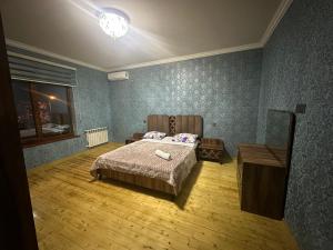 a bedroom with a bed and a wooden floor at Guest house in Qabala in Gabala