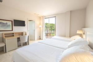 Postel nebo postele na pokoji v ubytování S'Agaró Hotel Spa & Wellness