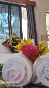 南迪的住宿－NeemTree Villa- 5 Bedroom House On Its Own，一张带两条毛巾和鲜花的床