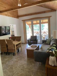 a living room with a couch and a table at Leśna Kryjówka domki w lesie in Wersk