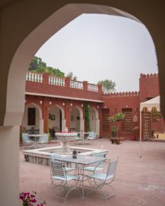 un patio con mesa y sillas y un edificio en Cavalry Villa bikaner, en Bikaner