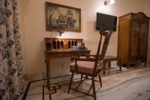 Habitación con escritorio con silla y TV. en Cavalry Villa bikaner, en Bikaner