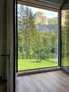 a large window in a room with a view of a yard at River Lilly Apartment in Obertraun