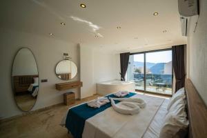 a bedroom with a large bed and a mirror at Villa Onat in Kalkan