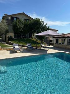 a swimming pool with two chairs and a house at Ferienhaus Marija mit Pool in Vilanija