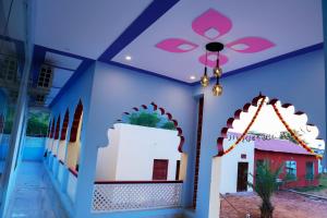 um quarto com uma ventoinha de tecto e uma casa em Savitri Valley Resort A Luxury Resort em Pushkar