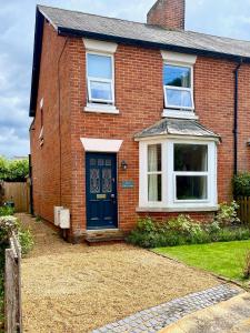 a red brick house with a blue door at Fallow Cottage in Lyndhurst