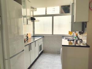 una cocina con armarios blancos y una ventana en Maravilloso apartamento en Torrejón de Ardoz, en Torrejón de Ardoz