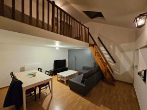 een woonkamer met een bank en een tafel bij La petite maison in Schiltigheim