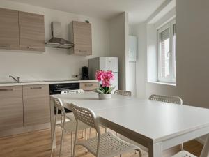 - une cuisine avec une table et des chaises blanches dans l'établissement Wauters 77 Bruxelles -charleroi-airport, à Charleroi