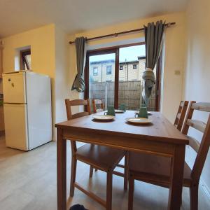 a kitchen with a wooden table and a refrigerator at All saints Rooms in London