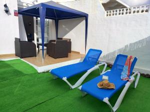 twee blauwe en witte stoelen op een groen tapijt bij Casa Yanira in Caleta De Fuste