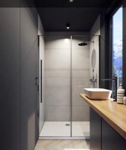 a bathroom with a glass shower with a sink at deichkind country loft in Achim