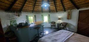 a room with a bed and a bar in a house at Mashai Rest Rondavel in Underberg