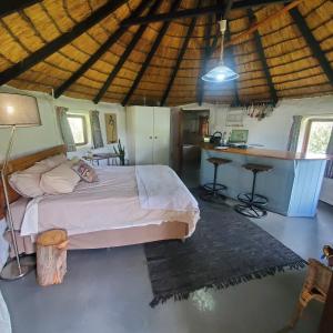 a bedroom with a bed and a desk in a room at Mashai Rest Rondavel in Underberg
