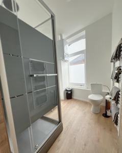 La salle de bains est pourvue d'une douche en verre et de toilettes. dans l'établissement Charbonnel 4 Bruxelles-Charleroi-airport, à Charleroi
