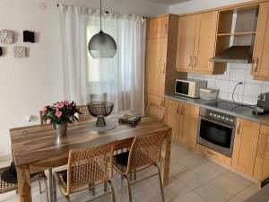 a kitchen with a wooden table and some chairs at Ferienhaus Marija mit Pool in Vilanija