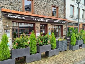 uma frente de loja com vasos de plantas em frente em Hebergement confort Comfortlogies La Fontanella em La-Roche-en-Ardenne