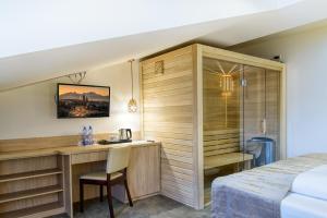 a hotel room with a desk and a bed at Penzión Berg in Kežmarok