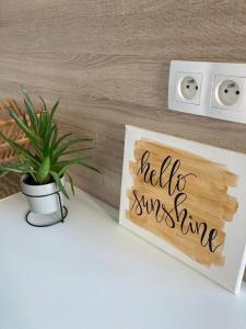 a potted plant on a table with a sign that reads hello sunshine at Útulný a moderný ateliér s terasou in Nivy
