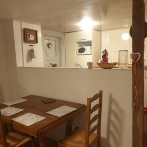 a kitchen with a wooden table and a table and chairs at Au jardin de Lucie in Sainte-Croix-en-Plaine