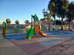 a playground with a slide in a park at Apartamento Playa de Xilxes. in Moncófar