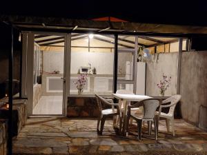 a table and chairs with a kitchen in the background at Stone rest house jebel shams in Al Ḩamrāʼ