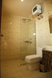 a bathroom with a toilet and a glass shower at Pearl Suites at Omaxe Eternity in Vrindāvan