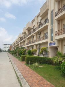 a row of apartment buildings next to a sidewalk at Pearl Suites at Omaxe Eternity in Vrindāvan
