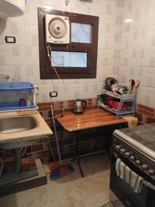 a kitchen with a table with a sink and a microwave at furnished apartment 10th of ramadan- شقة مفروشة in Madinat Al Ashir min Ramadan