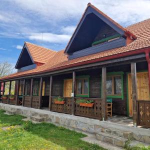 a wooden house with windows and a roof at Alpine Escape Studios in Măgura