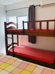a bedroom with two bunk beds with red sheets at Carapibus, Conde PB in Conde
