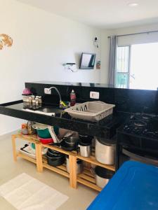 a kitchen with a sink and a counter with pots and pans at Carapibus, Conde PB in Conde