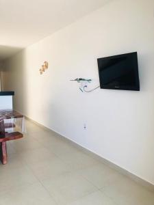 a living room with a flat screen tv on a white wall at Carapibus, Conde PB in Conde +47 photos