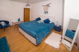 um quarto com uma cama com um edredão azul e um espelho em The Terrace em Ponta Delgada