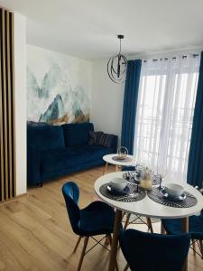 sala de estar con mesa y sofá azul en Apartament w Białce Tatrzańskiej en Białka Tatrzanska