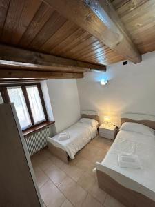 two beds in a room with two windows at Hotel Oberje DLa Viere in Oulx