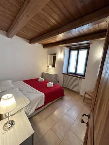 a bedroom with a bed with a red blanket at Hotel Oberje DLa Viere in Oulx