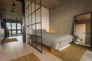 a bedroom with a bed and a large glass wall at Industrial Luxury City Loft in Gothenburg