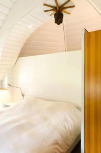 een slaapkamer met een wit bed en een plafondventilator bij Historical house on river Vecht in Maarssen