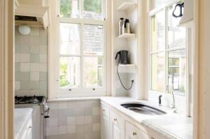 a kitchen with a sink and two windows at Historical house on river Vecht in Maarssen