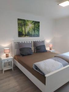a bedroom with a large bed with two lamps on it at Haus Kellerwald - Ferienwohnung Kellerwald-Edersee in Jesberg
