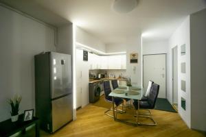 a small kitchen with a table and a refrigerator at Uptown Elegant Apartment in Voluntari