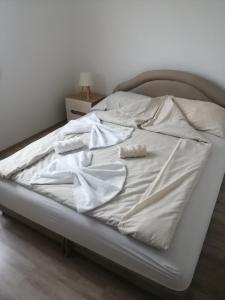 a bed with white sheets and two pillows on it at Kuća za odmor Jovana&Ivona 2023 OBRADOVIĆ SOKAK 41 in Šimanovci