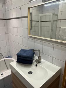 een badkamer met een wastafel met een blauwe handdoek erop bij Ortners Ferienwohung in Bischofshofen