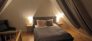 a bedroom with a bed with two pillows and a chair at Svencelė Cottage K18 in Svenele
